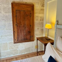 Placard ancien en bois et table de chevet contre le mur en pierre – Les Hirondelles, Villeneuve-lès-Avignon
