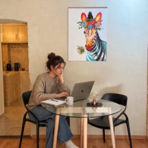 Coin repas avec table ronde en verre et tableau coloré – Les Hirondelles, Villeneuve-lès-Avignon