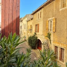 Vue depuis la fenêtre sur la ruelle et ses façades aux volets colorés – Les Hirondelles, Villeneuve-lès-Avignon